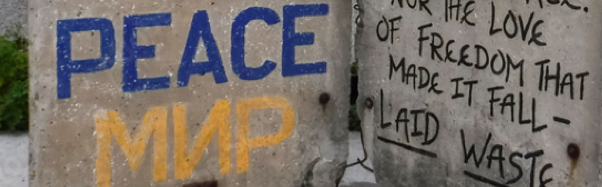 restant Berlijnse muur waar nu een extra booschap in Engels/Russisch is bijgeschreven: peace/mir