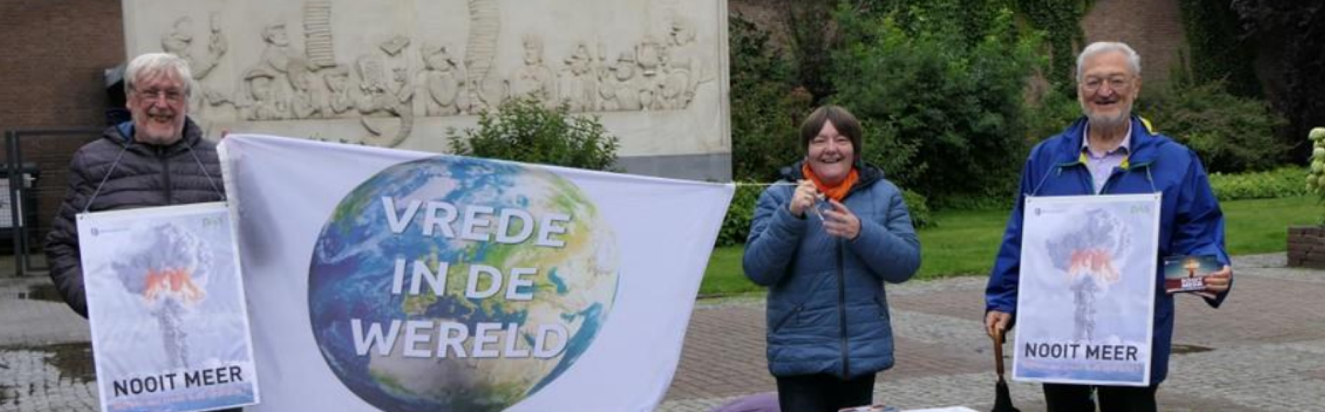 actie bij bibliotheek met spandoek en 3 mensen