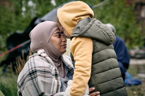 (Moslim) moeder en zoon in een kamp knuffelen elkaar. Voorhoofd aan voorhoofd. Liefde, vrede begint thuis.