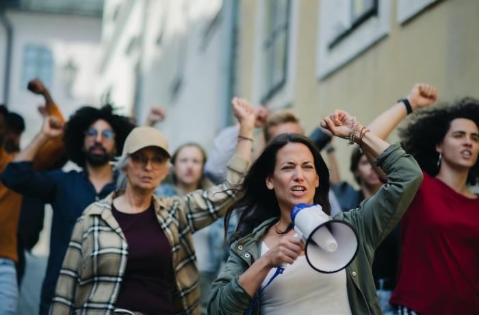 groepen mensen die protesteren met handen in lucht en microfoon