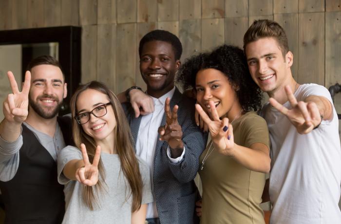 Diverse groep jongeren tonen het vredesteken met de hand