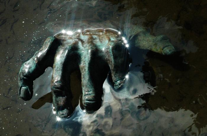 beeld van hand die uit de aarde terugkomt