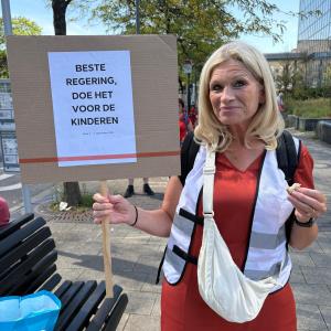 Kristina houdt trots een bordje vast met een ingestuurde slogan
