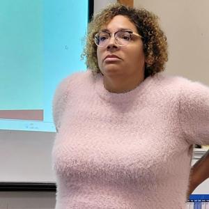 Onze bewegingswerker Bénédicte Kusendila luistert aandacht naar een deelnemer tijdens de workshop.
